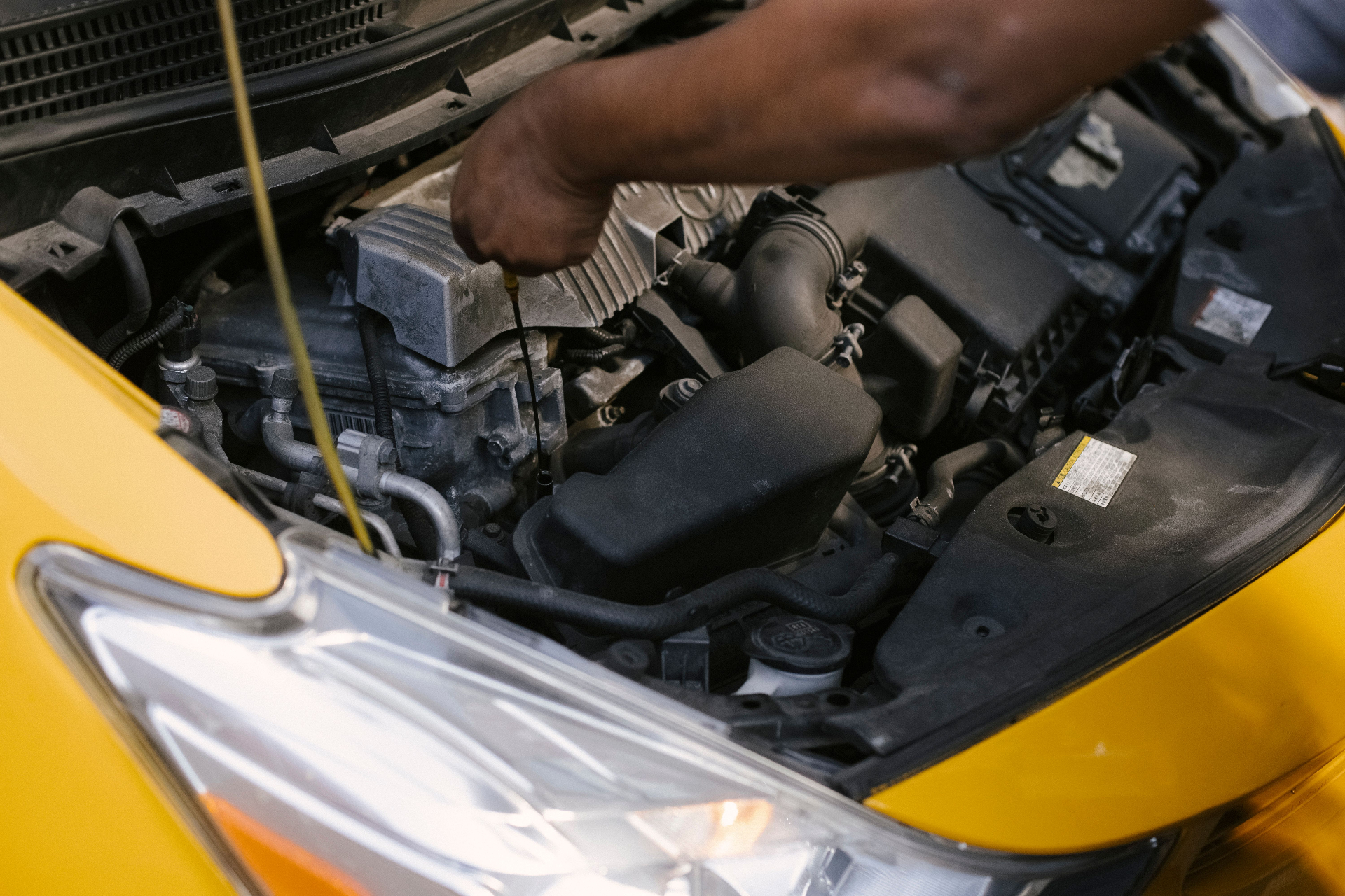 Mechanic performing engine bay dipstick oil-level check and vehicle diagnostics at Mega Body Auto Maitland, Cape Town