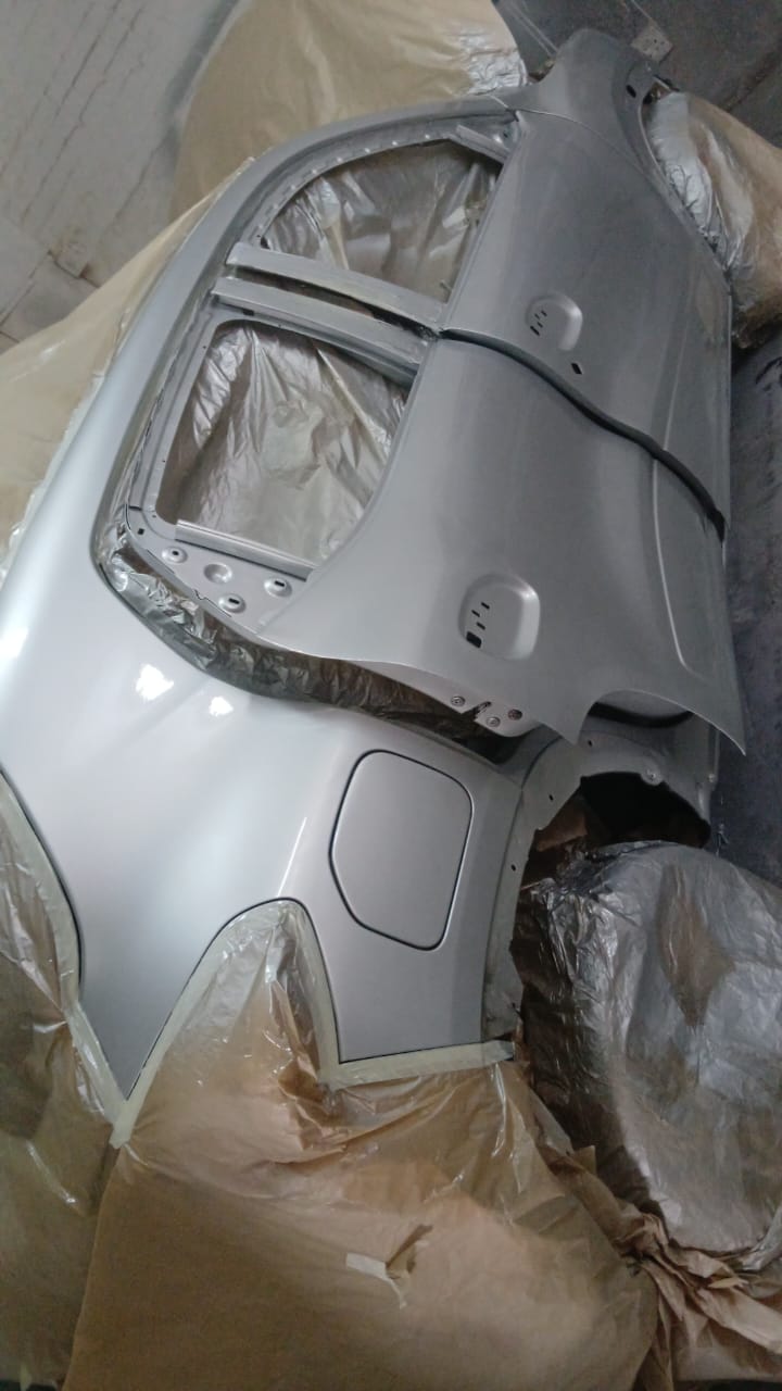 VW Polo rear quarter panel in silver primer prepared for respray inside Mega Body Auto's Maitland spray booth