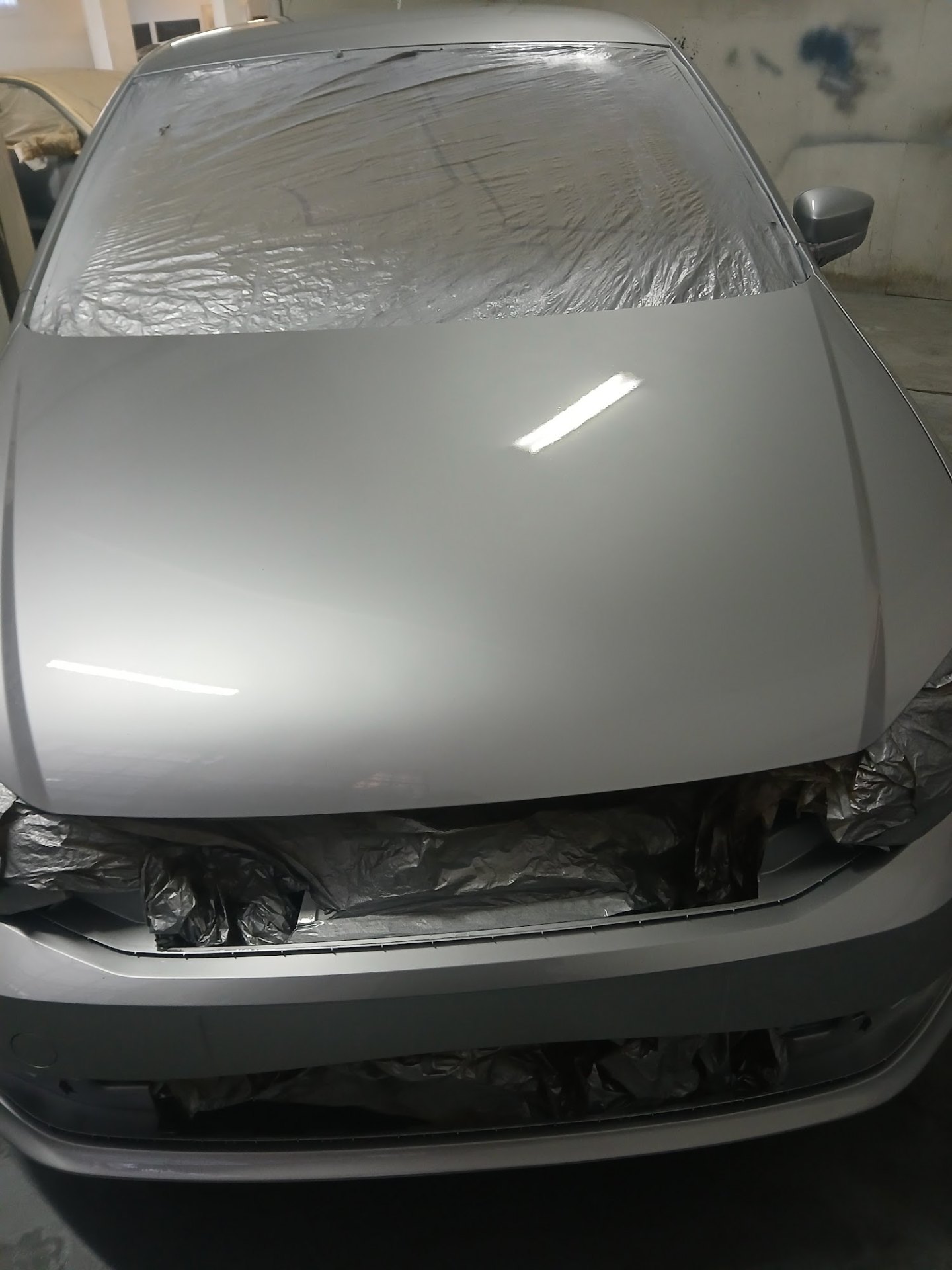 Silver VW Polo bonnet with fresh metallic respray gloss finish inside Mega Body Auto spray booth Cape Town