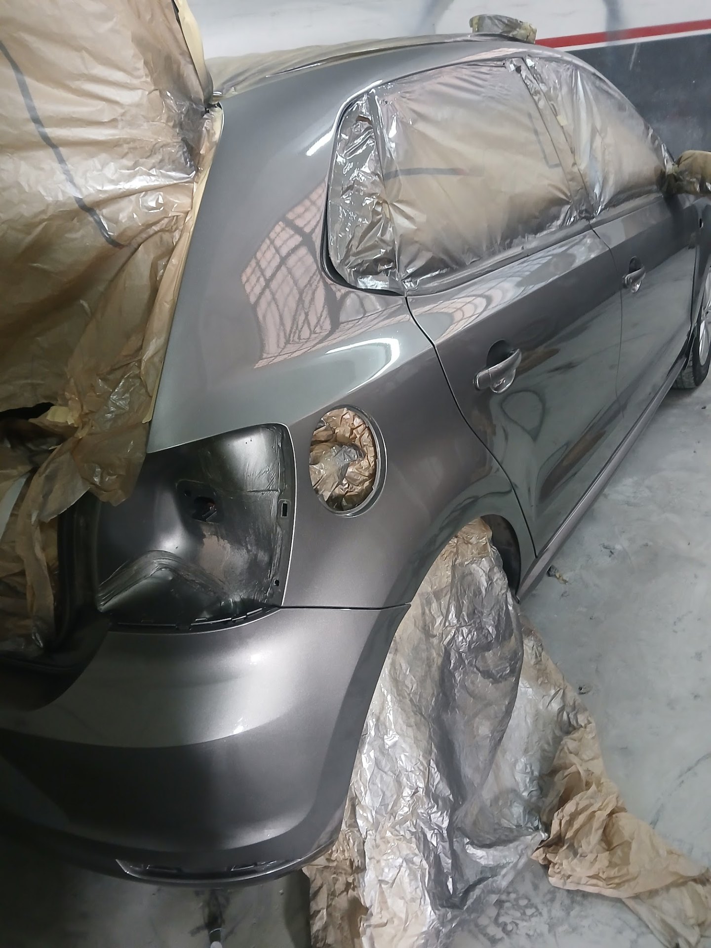 Grey VW Polo rear quarter panel and bumper masked and resprayed in dark grey metallic at Mega Body Auto Maitland